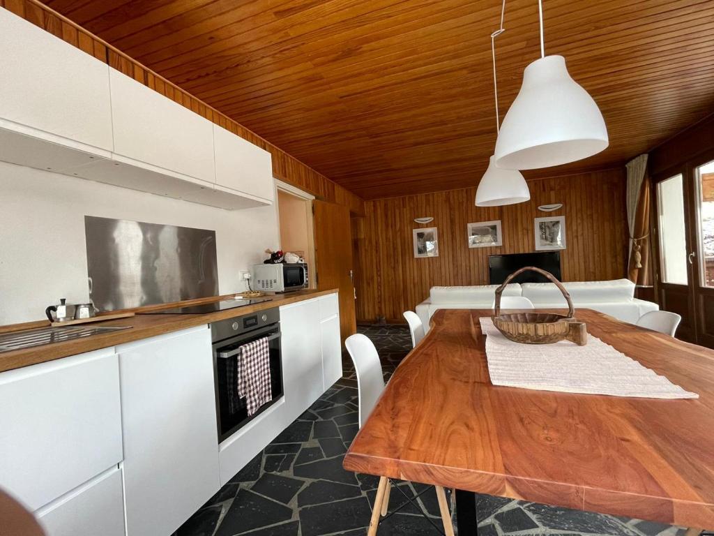 een keuken en eetkamer met een houten tafel bij Lovely Apt Chalet Courchevel 1650 in Courchevel