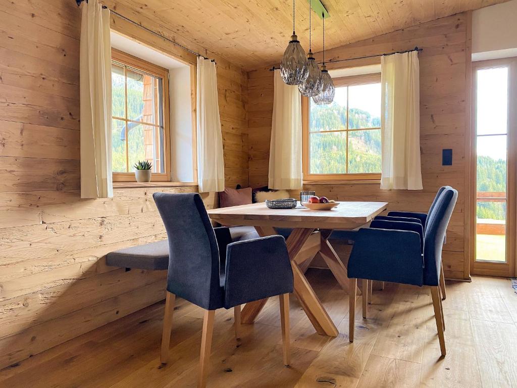 uma sala de jantar com uma mesa e cadeiras azuis em Chalet Tuxer em Achenkirch