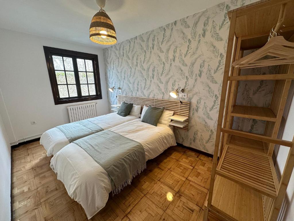 a bedroom with a large bed and a wooden ladder at Apartamento Plaza del Rey in Santillana del Mar