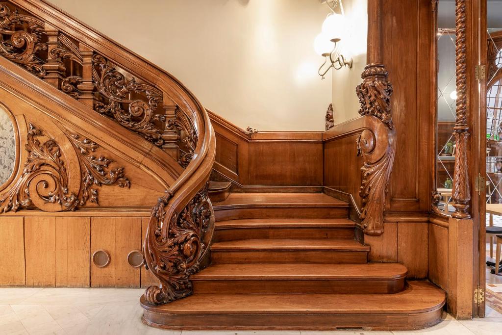 an ornate wooden staircase in a home with wooden walls at El Palauet Royal Suites in Barcelona