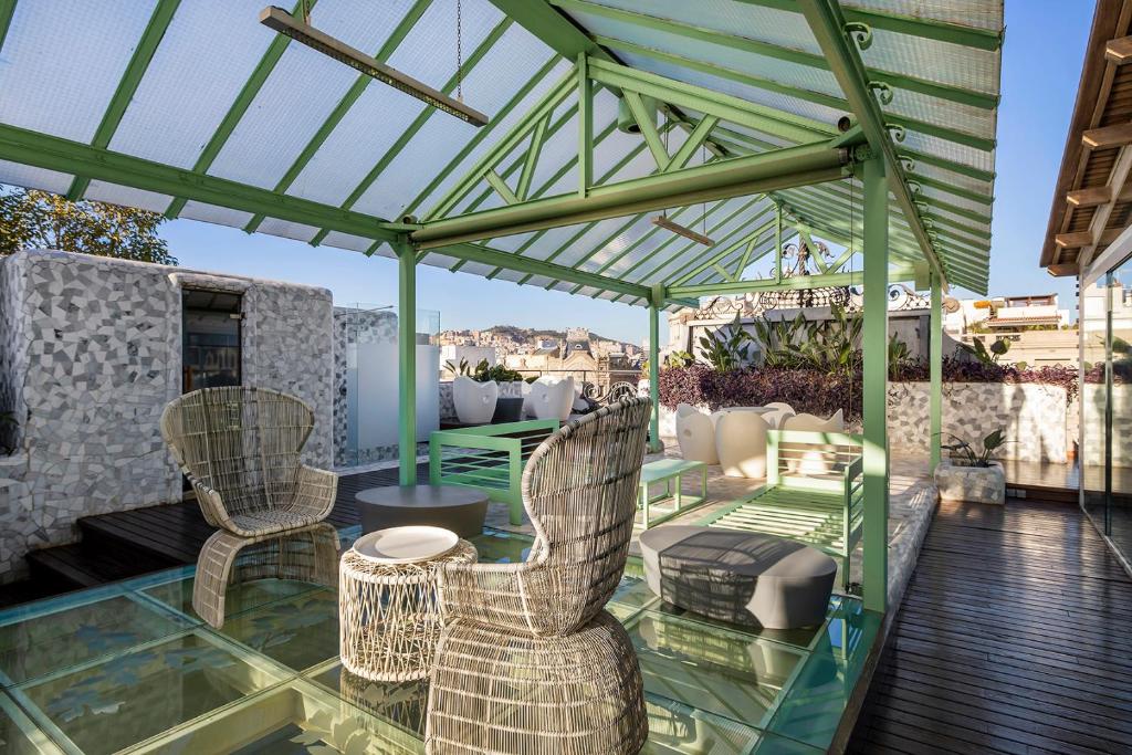 a patio with two chairs and a glass roof at El Palauet Royal Suites in Barcelona