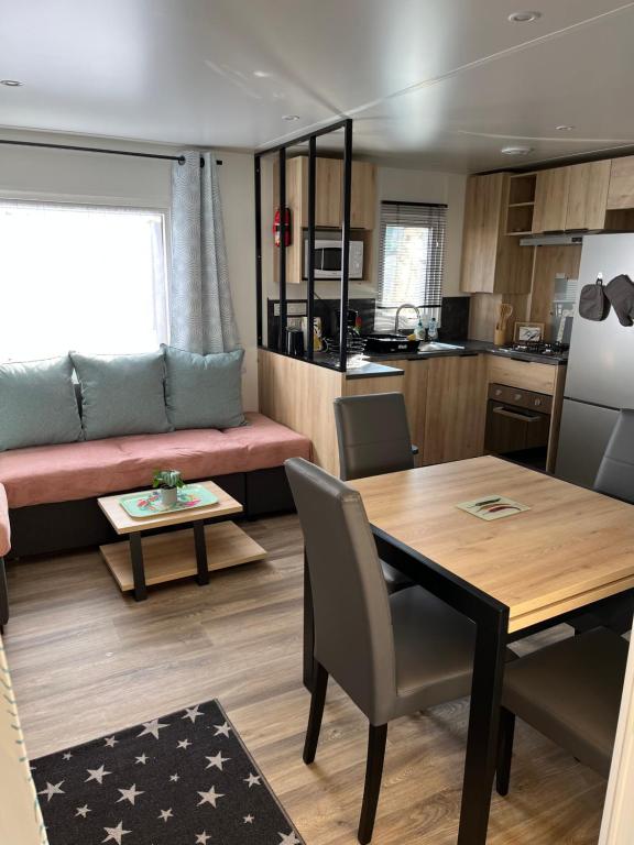 a kitchen and living room with a table and a couch at Mobilhome bora bora in Pont-Aven