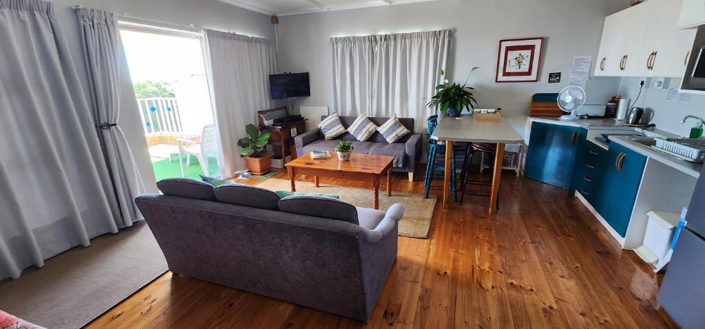 a living room with a couch and a table and a kitchen at Breakaway Apartment with Balcony in Yzerfontein