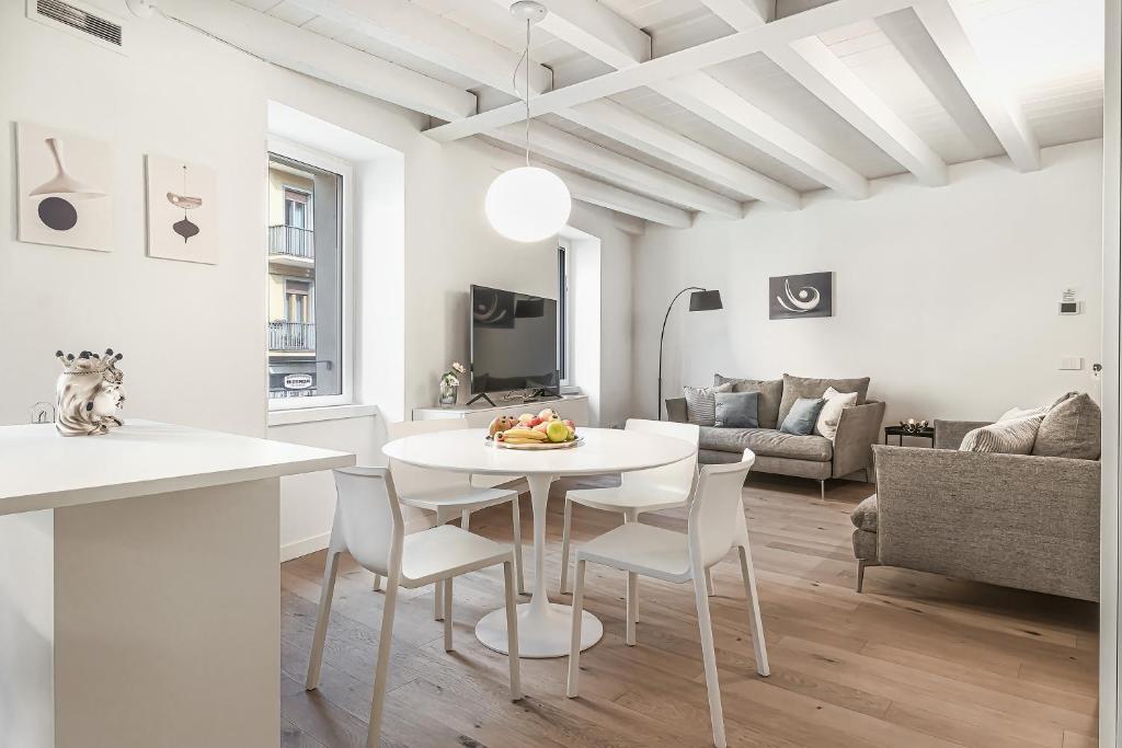 een keuken en een woonkamer met een witte tafel en stoelen bij Porta Palio Luxury Apartment in Verona