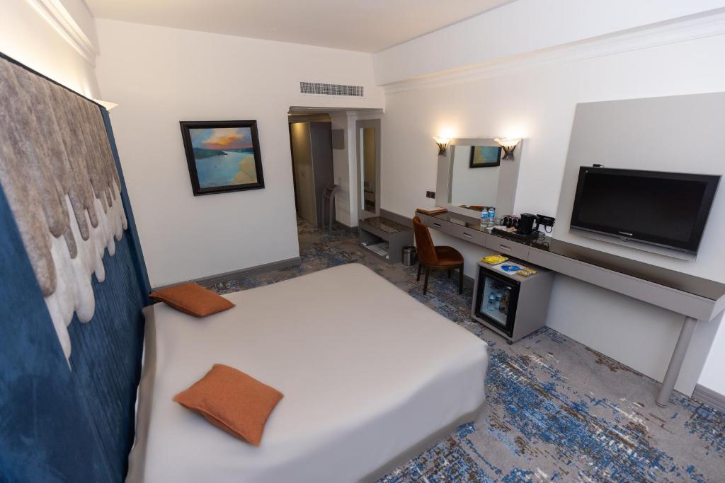 a hotel room with a bed and a desk at Dilshad Palace Hotel in Duhok