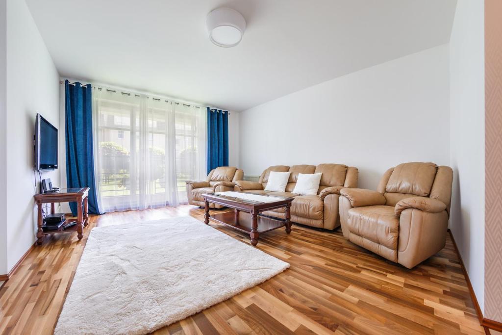 a living room with a couch and a table at Apartamenty Sun & Snow Parkur in Sopot