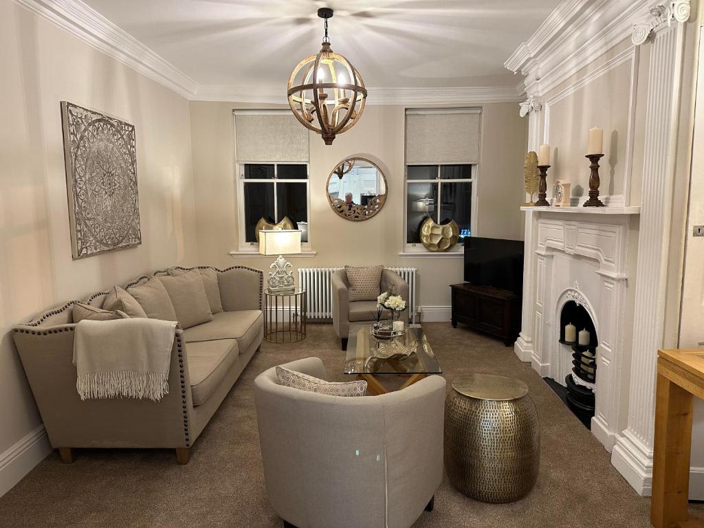 a living room with a couch and a fireplace at Strother's Townhouse in Berwick-Upon-Tweed