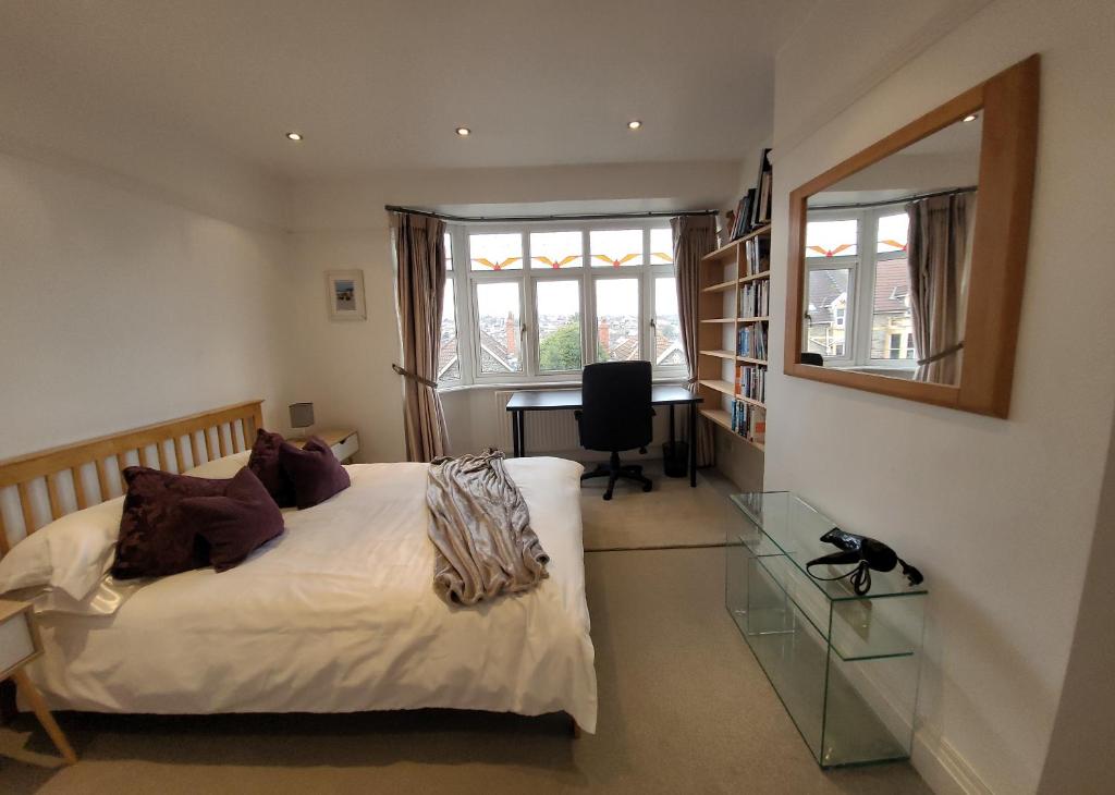 a bedroom with a bed and a desk and a window at Quiet Terraced House in Bristol
