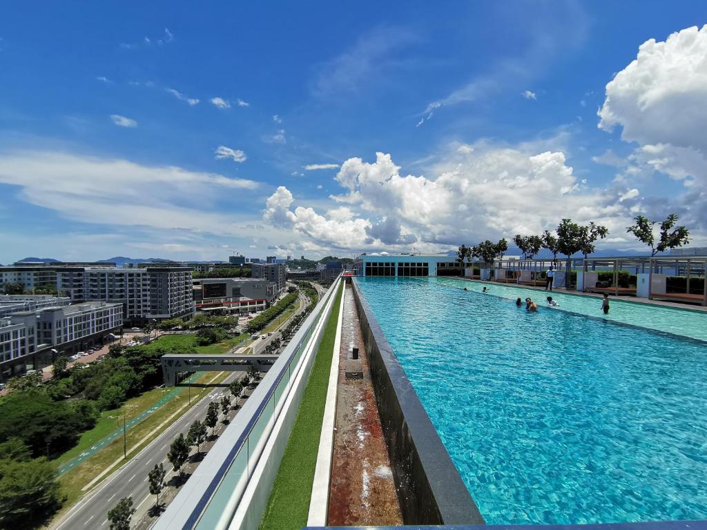 a swimming pool with blue water in a city at Greenage 绿色时代 at Sutera Avenue in Kota Kinabalu