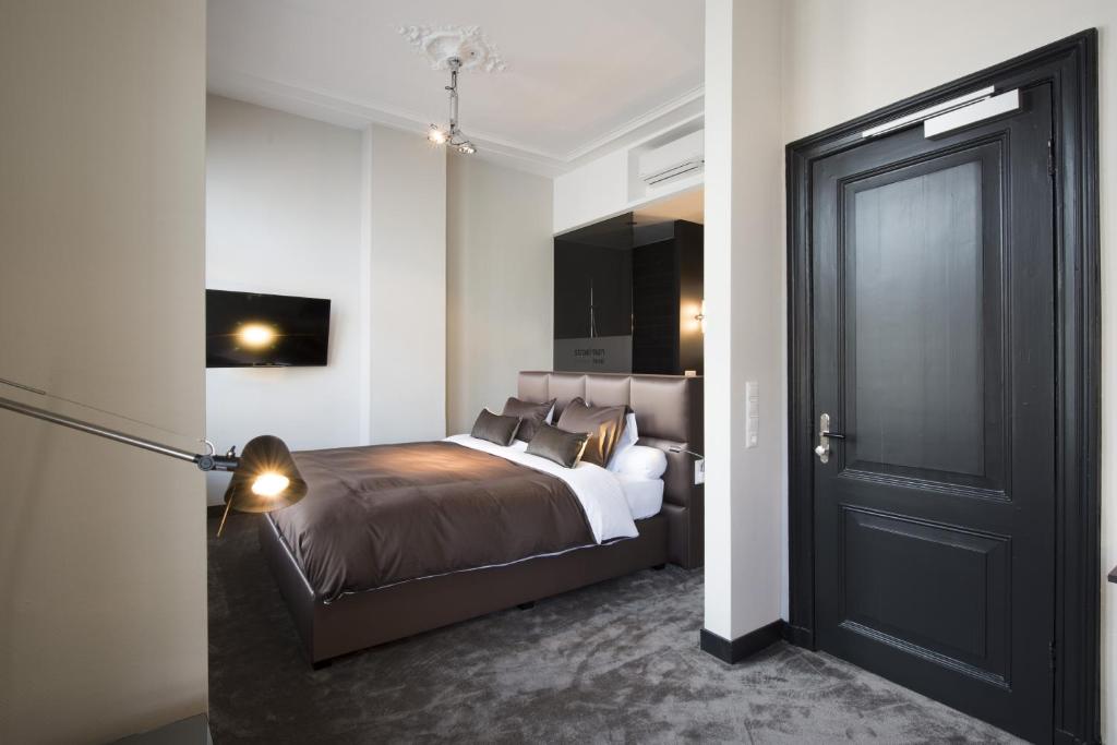 a bedroom with a bed and a black door at Boutique Hotel Straelman in Nijmegen