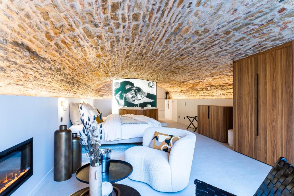 Cette chambre comprend un lit, un canapé et une télévision. dans l'établissement Legend Majestic SPA - Insolite & Unique - Champagne - Parking privé, à Bourg-en-Bresse