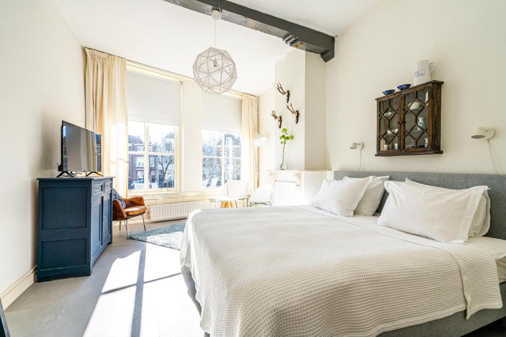 een slaapkamer met een groot bed en een televisie bij Nr 19 Bed and Bubbels in Middelburg