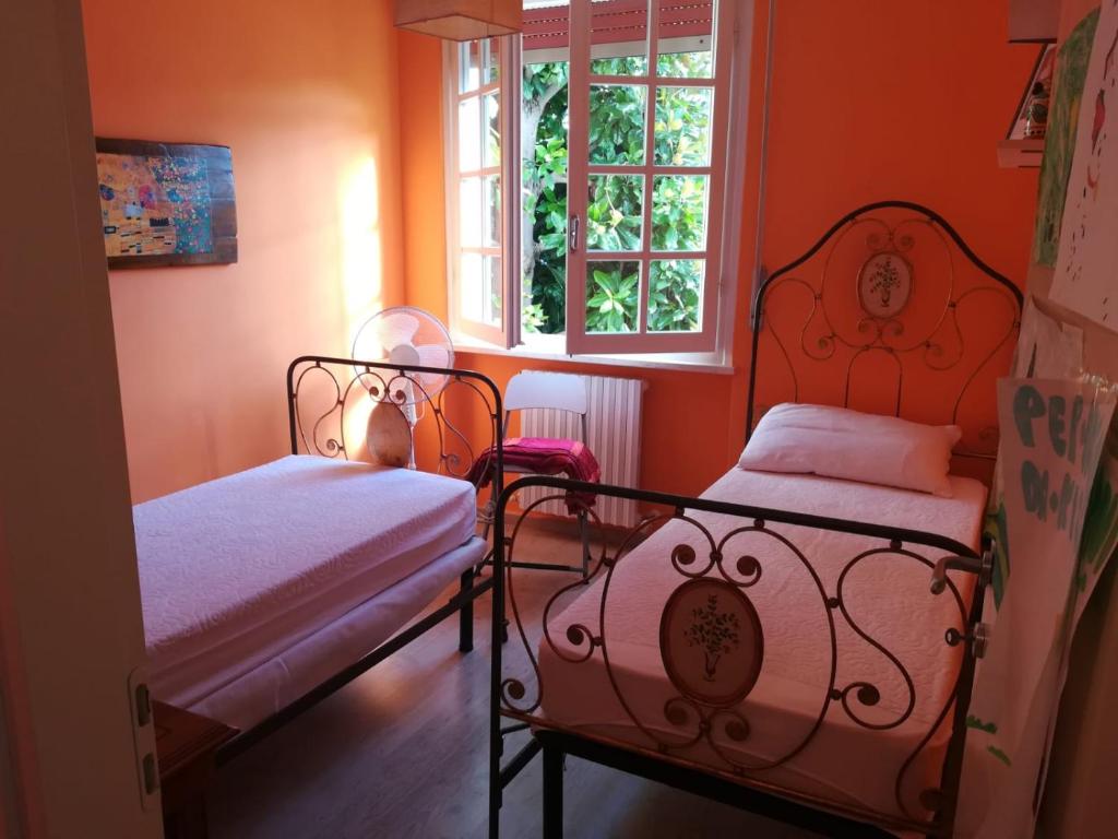 two beds in a room with orange walls at Il Ritiro Estivo in Rosignano Solvay