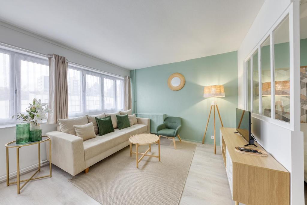 uma sala de estar com um sofá e uma televisão em Appartement à Evry, cossu, avec parking em Évry-les-Châteaux