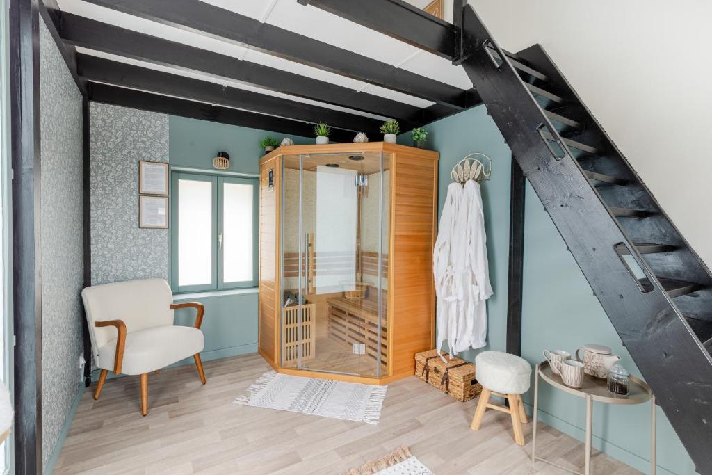 a room with a mirror and a chair and a dressing room at La Maison Melo - Jacuzzi et Sauna - proche de la plage in Saint-Méloir-des-Ondes