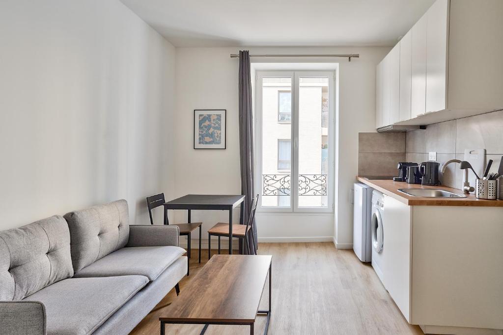 sala de estar con sofá y mesa en Cosy Residence Paris Sud, en Ivry-sur-Seine
