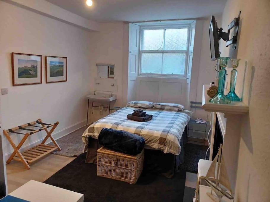 een kleine slaapkamer met een bed en een raam bij The Wee Room -Stay Where All St Andrews is on the Doorstep! in Fife