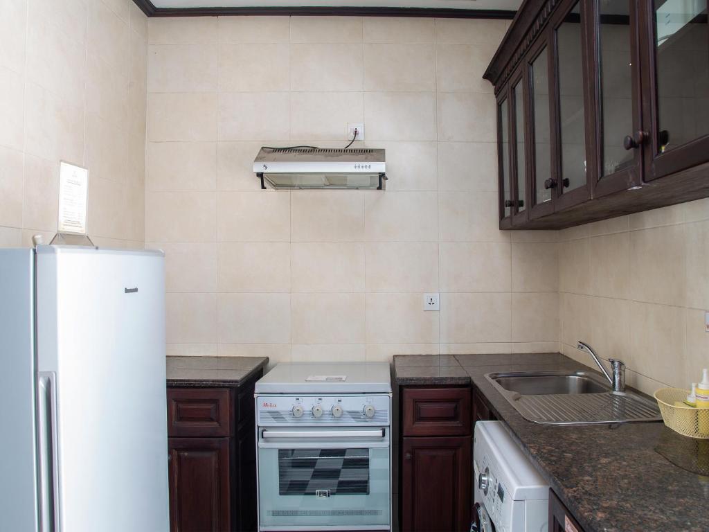 a kitchen with a white stove and a sink at Chateau d'Angkor La Residence in Siem Reap