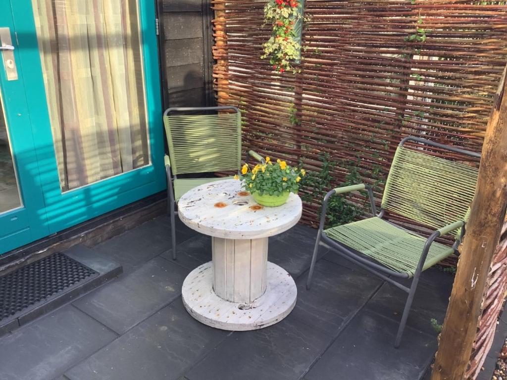 un tavolo e 2 sedie su un patio di Atelier Zonnehoek a Bergen
