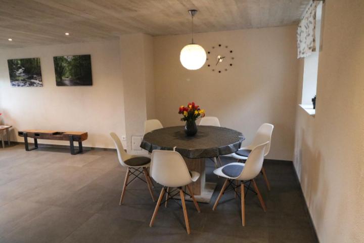 ein Esszimmer mit einem Tisch und Stühlen mit einer Blumenvase in der Unterkunft Ferienwohnung Am Pfaffenderbach in Ralingen
