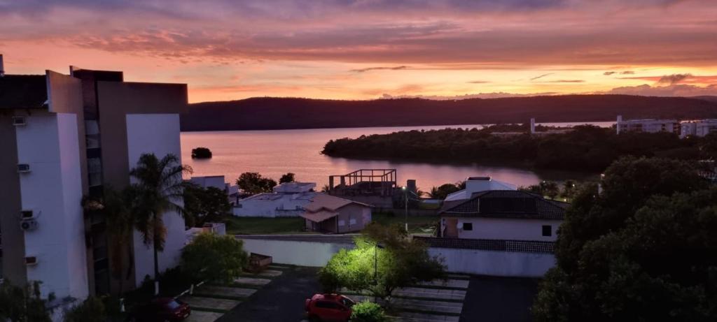 a sunset over a body of water next to a city at Enseada Náutico Apart Flat Quinto Andar in Caldas Novas