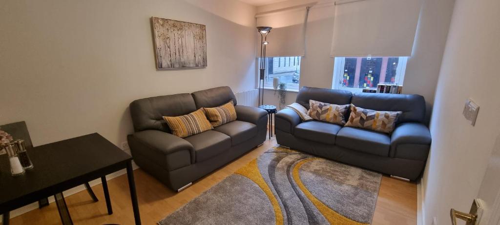 uma sala de estar com dois sofás e uma mesa em Merchantcityflat em Glasgow