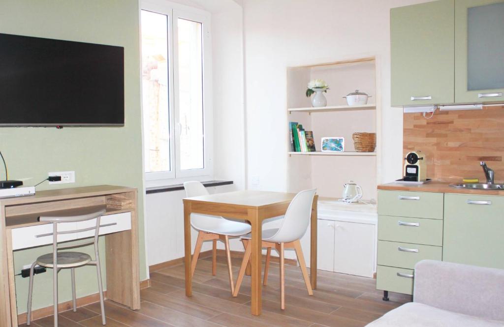 a kitchen with a table and chairs in a room at Studio DolceCasa Menton in Menton