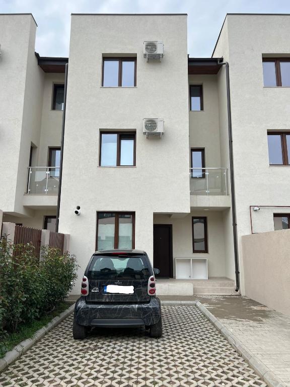 a car parked in front of a building at Vila Nova Residence in Popeşti-Leordeni