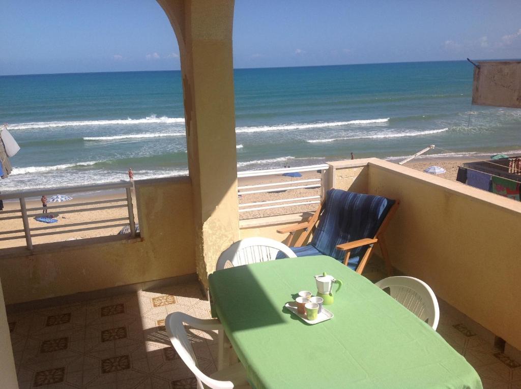 una mesa verde y sillas con vistas a la playa en Il Sole di Nonno Ciccio, en Alcamo Marina