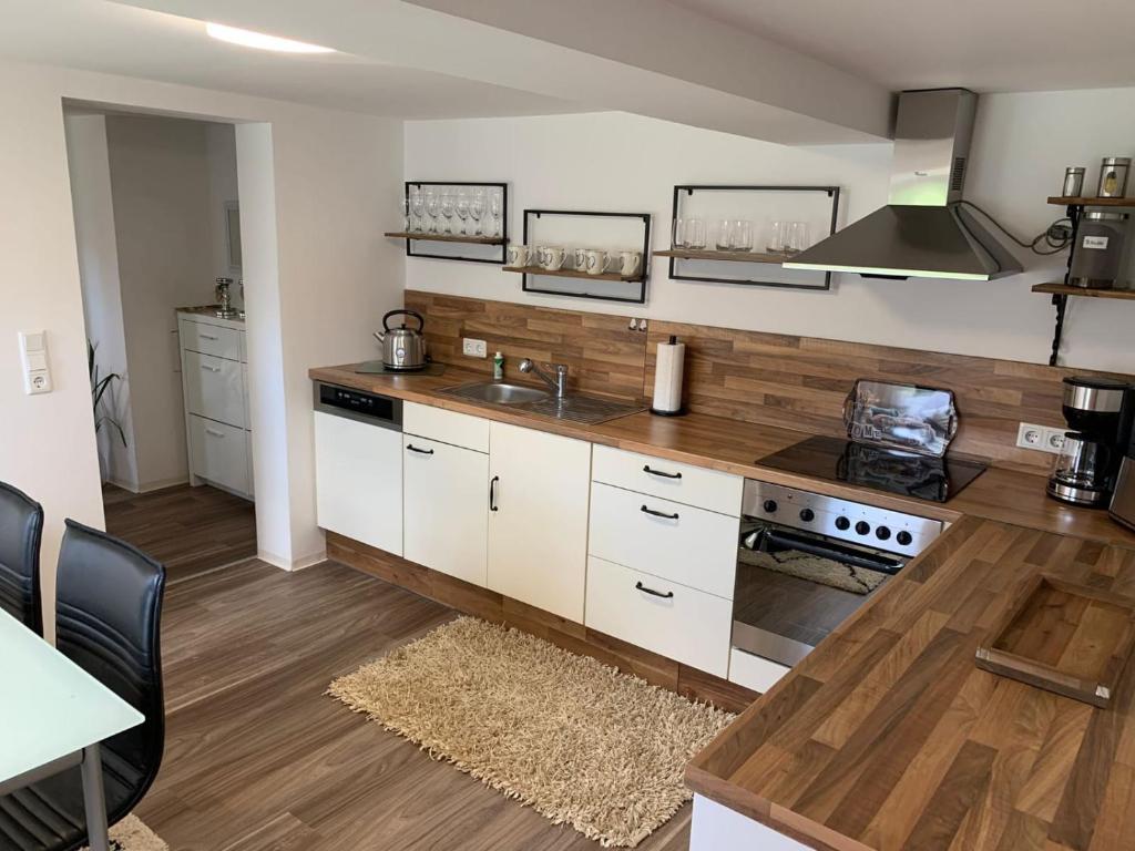 cocina con armarios blancos y encimera en NEU Ferienwohnung MONTE in Walsrode en Walsrode