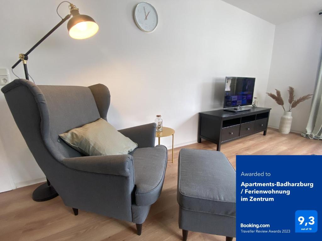 a living room with a chair and a television at Apartments-Badharzburg / Ferienwohnung im Zentrum in Bad Harzburg