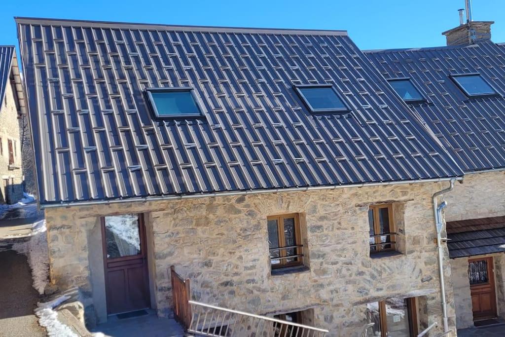an old stone building with a tile roof at Maison de village au cœur du hameau Les Marches à Orcières in Orcières