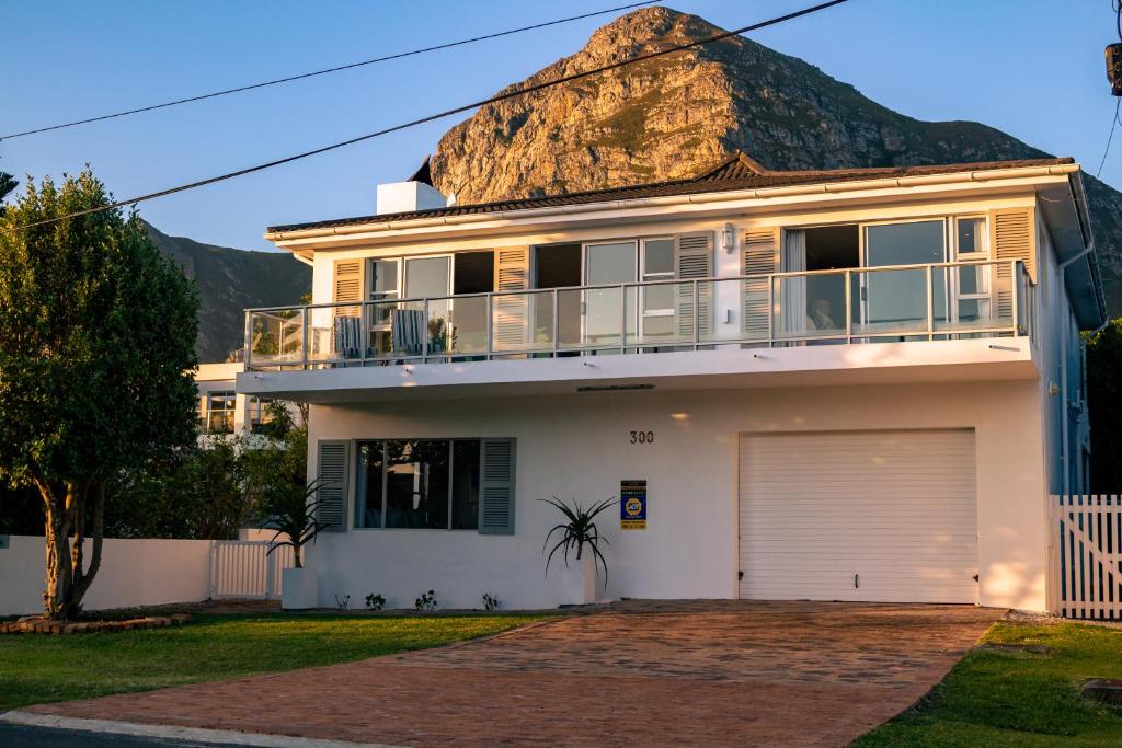 a large white house with a rock at Hermanus Family Getaway - Near The Beach in Hermanus