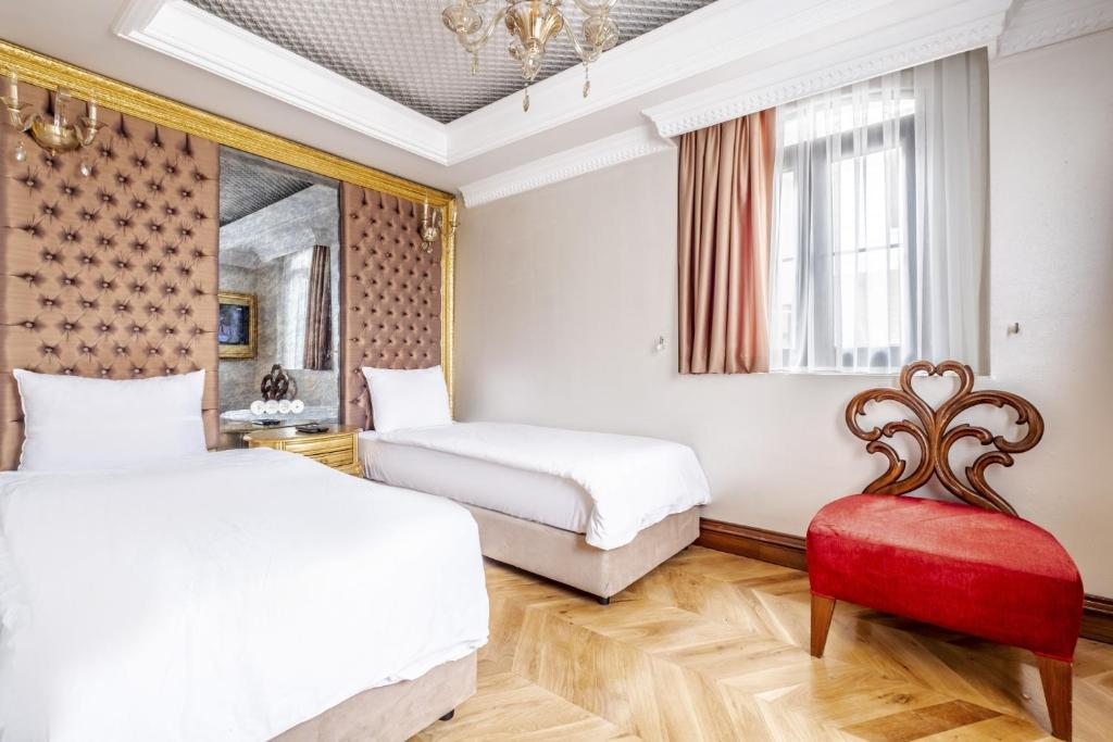 - une chambre avec deux lits et une chaise rouge dans l'établissement Glamorous Authentic Studio in Üsküdar, à Istanbul