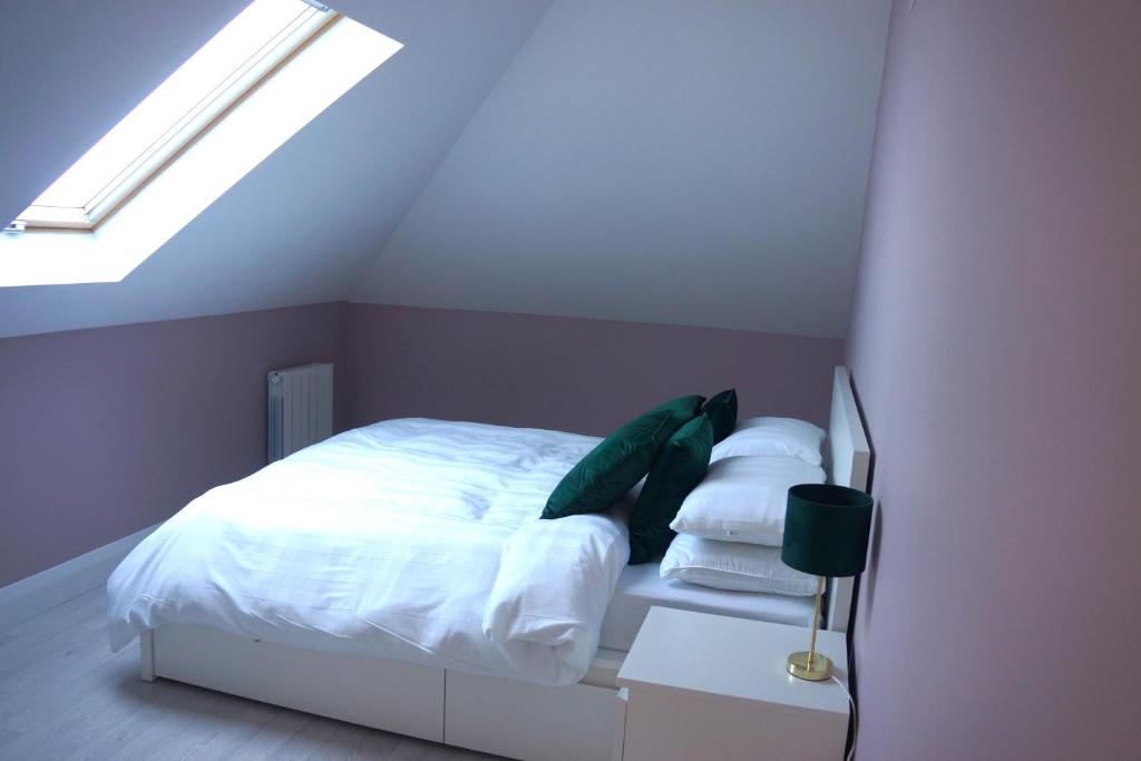 una camera da letto con letto, lenzuola e cuscini bianchi di Àit Sèan Òg - 2bedroom self catering apartment 