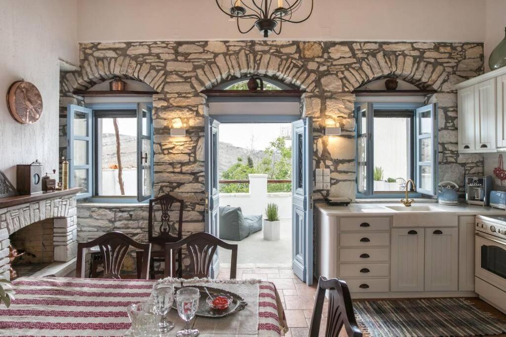 a kitchen with a table and a stone wall at Traditional Inn Pirethron in Apeiranthos