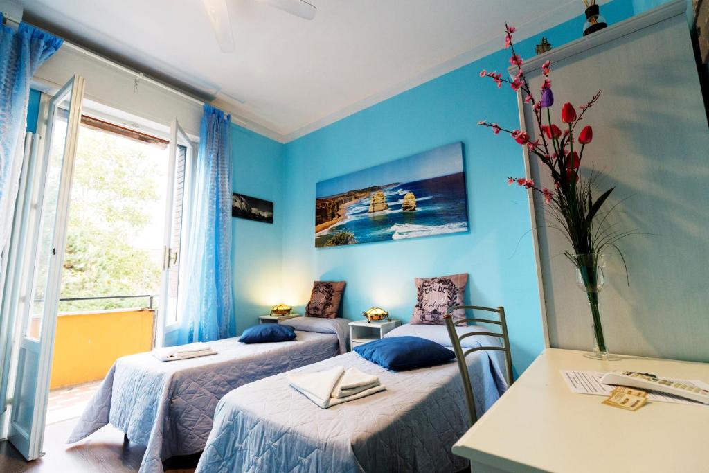 two beds in a room with blue walls at B&B ARCOVEGGIO in Bologna