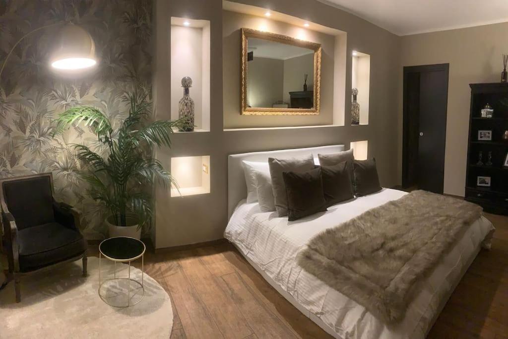 een slaapkamer met een bed, een spiegel en een stoel bij Casa di Alice- Veratti in Milaan