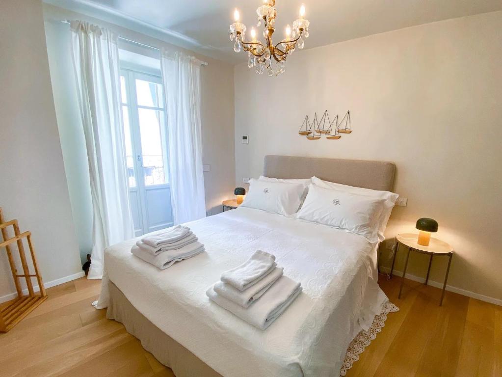 a bedroom with a white bed with towels on it at La Motta in Belgirate