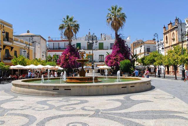 fontanna w środku miasta z palmami w obiekcie VILLA SALMONETE w mieście Sanlúcar de Barrameda