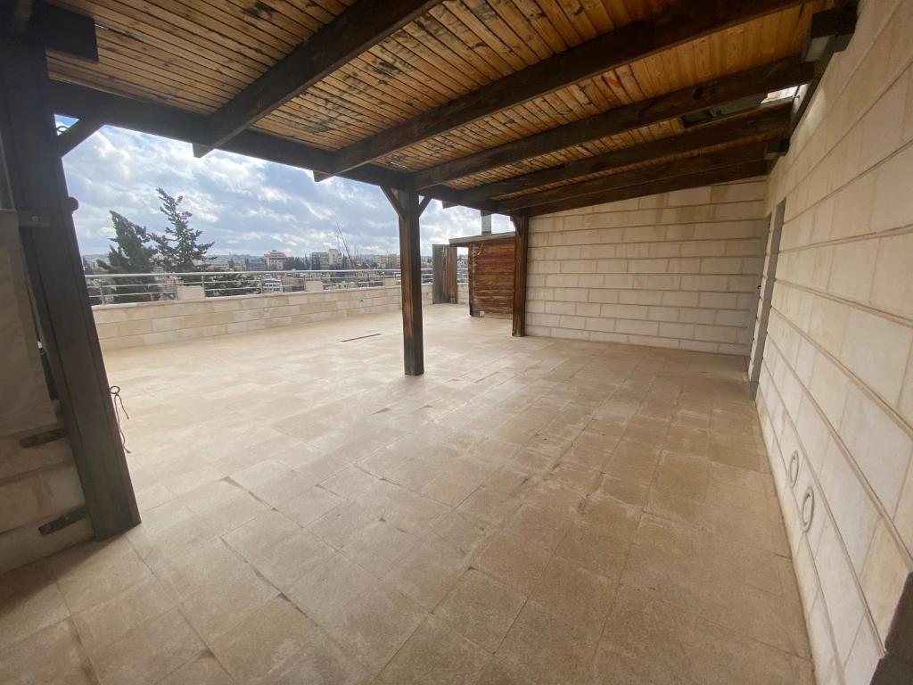 an empty building with a roof with a wooden ceiling at Lemon Tree Residence in Amman