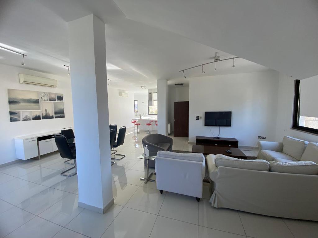 a living room with a couch and a table and chairs at Lemon Tree Residence in Amman
