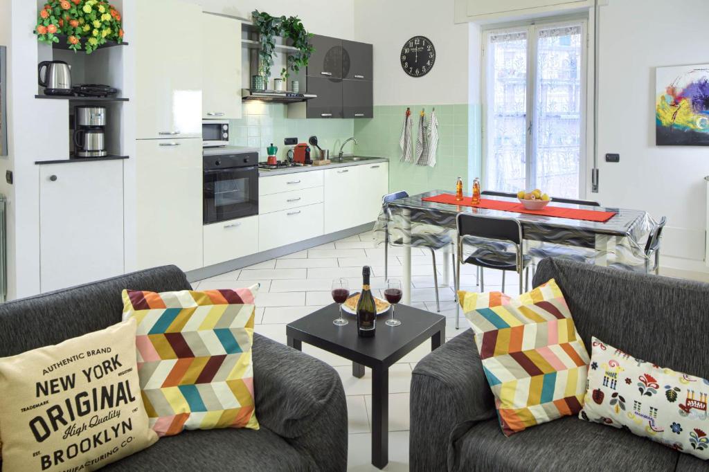 uma cozinha e sala de estar com dois sofás e uma mesa em Fernanda 2 em Levanto