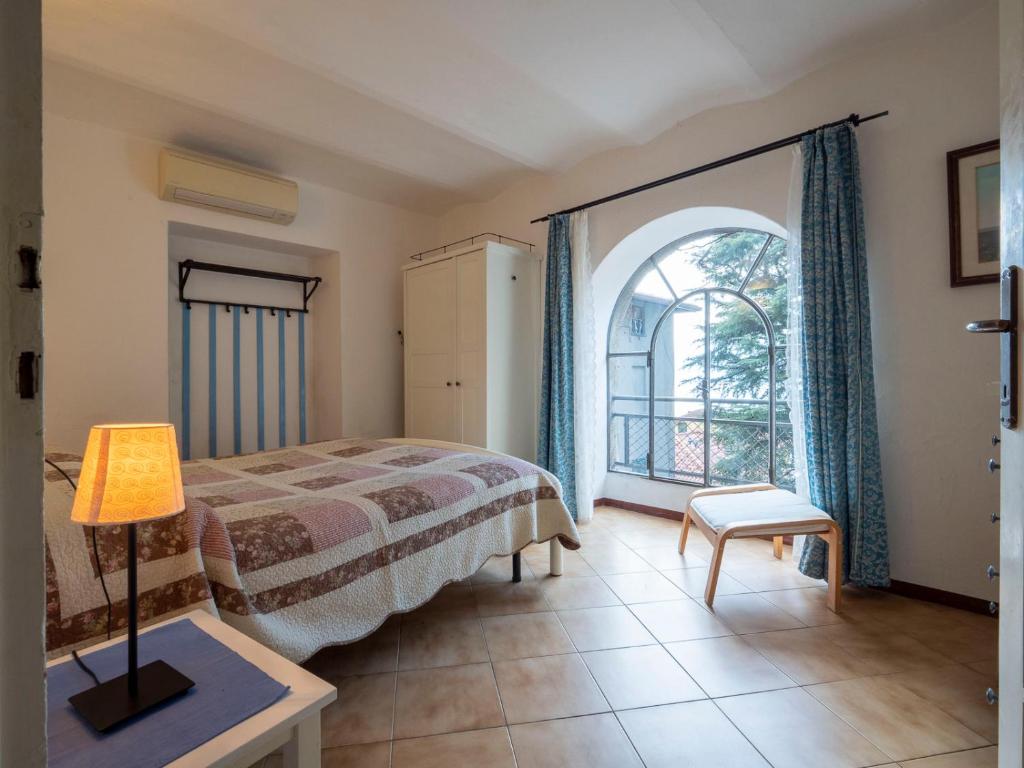 a bedroom with a bed and a large window at Villa Albertina in Varenna