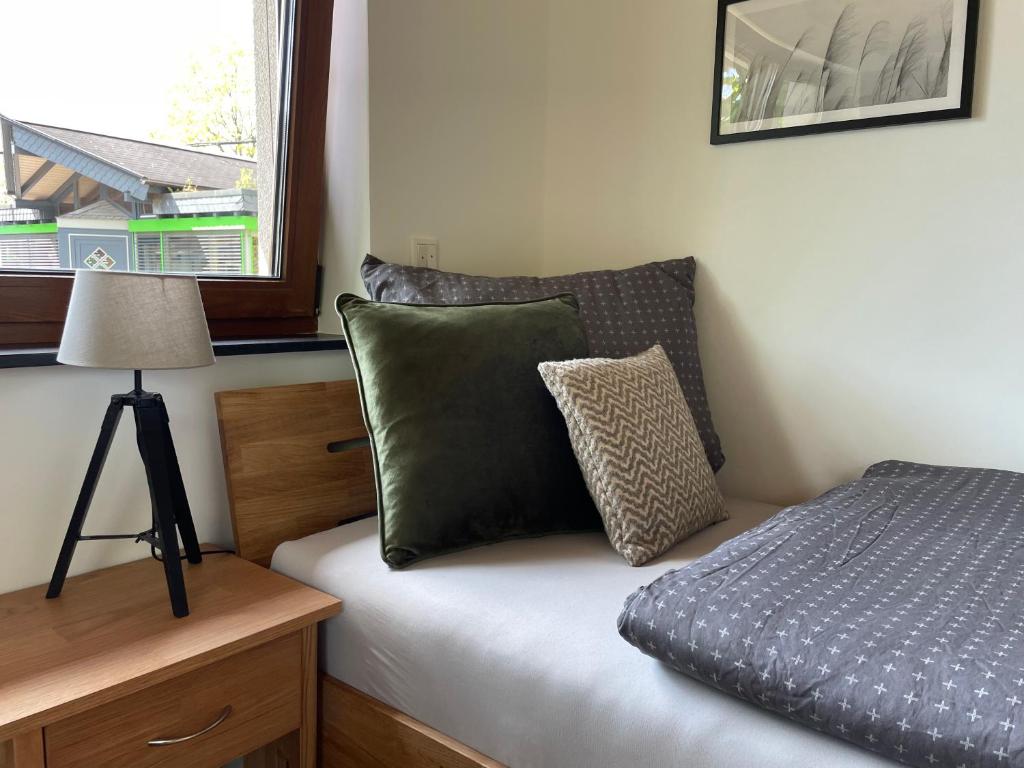 ein Schlafzimmer mit einem Bett, einer Lampe und einem Fenster in der Unterkunft Rönkhausen Appartements in Finnentrop