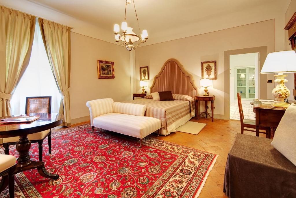 une chambre avec un lit et un salon dans l'établissement Villa Il Sasso - Dimora d'Epoca, à Bagno a Ripoli