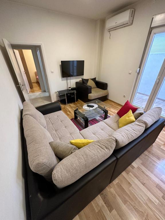 een grote bank in een woonkamer met een televisie bij Selena apartment in Podgorica