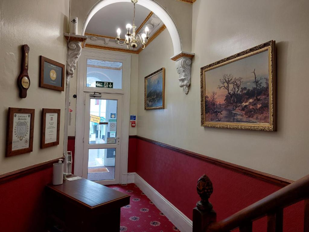 a hallway with a staircase with a painting on the wall at The Norwood in Torquay