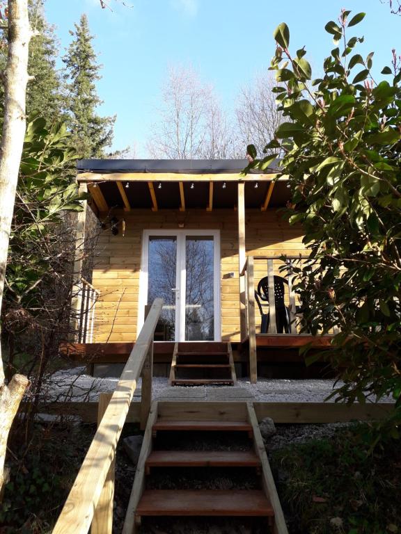 um chalé de madeira com escadas que levam à porta da frente em La Pointe Camping em Châteaulin