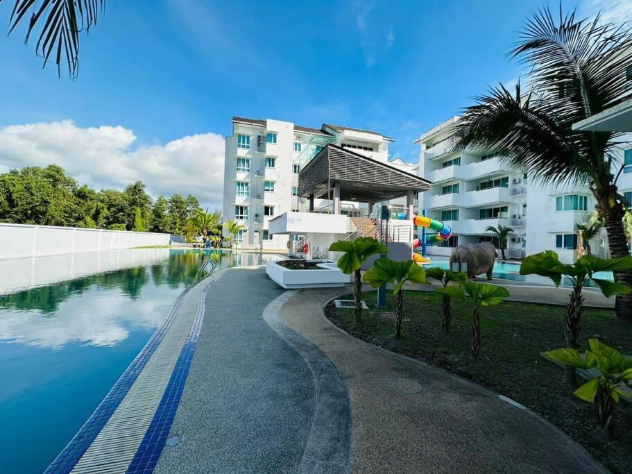 a swimming pool in front of a building at Homelite Resort in Miri